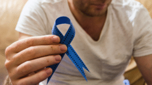 Homem segurando um laço azul, para falar se é possível prevenir o câncer de próstata