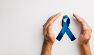Homem com um laço azul entre as mãos, para falar sobre a relação entre o PSA alto e o câncer de próstata