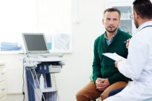 Paciente ouvindo o médico sobre se o tratamento do câncer de próstata pode causar impotência