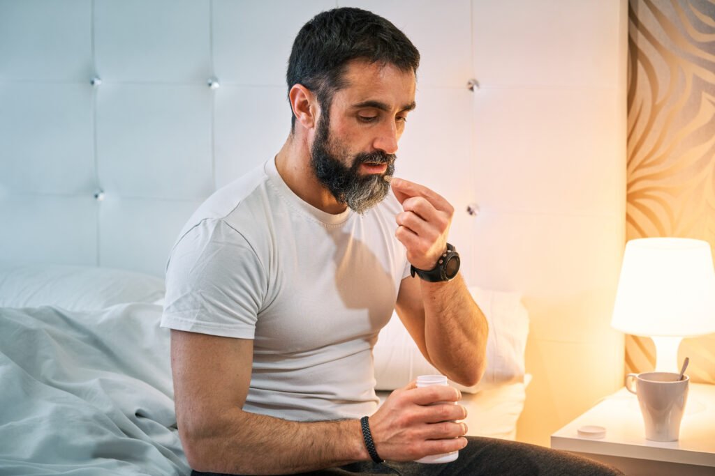 Homem tomando um comprimido, pensando no tratamento da próstata aumentada