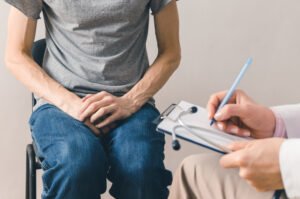 Homem consultando com neurologista para saber sobre os sintomas iniciais do câncer de próstata.